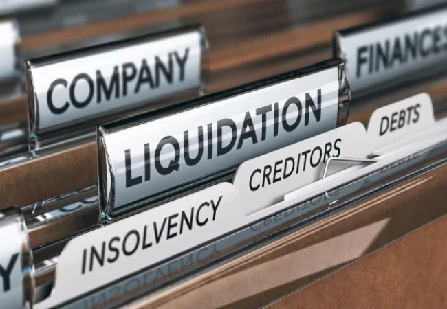 File folders with labels relating to financial distress and company closure, including 'liquidation', 'creditors', and 'insolvency'